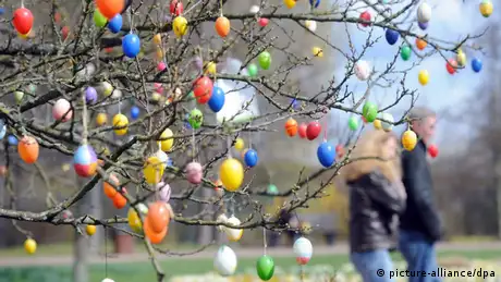 Ein Baum mit farbigen Ostereiern und Spaziergänger
Foto: Maurizio Gambarini dpa/lbn 