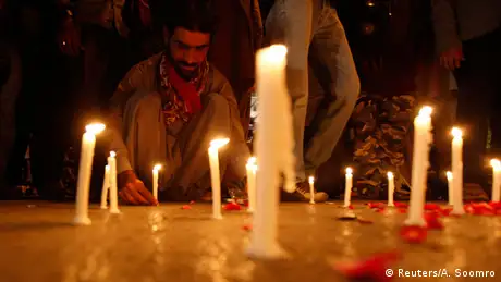 A man lights candles to mourn the victims from the Army Public School in Peshawar, which was attack by Taliban gunmen, in Karachi, December 16, 2014.