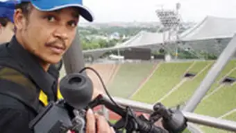 Video journalist with a camera in a stadium