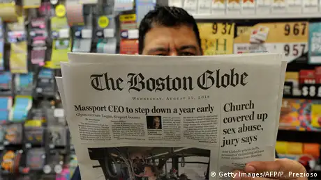 in a shop in Bosten, a man reads an 2018 issue of The Boston Globe newspaper with headline Chruch covered up sex abuse, jury says
