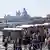 Touristen gehen am Markusplatz in Venedig an zahlreichen Souvenirständen vorbei, Italien