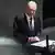 Muškarac srednjih godina, ćelav, u odijelu s kravatom, za govornicom u Bundestagu, ozbiljnog pogleda