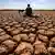 Varfëri për shkak të ndryshimit të klimës, djalë vetë i ulur në tokë të tharë